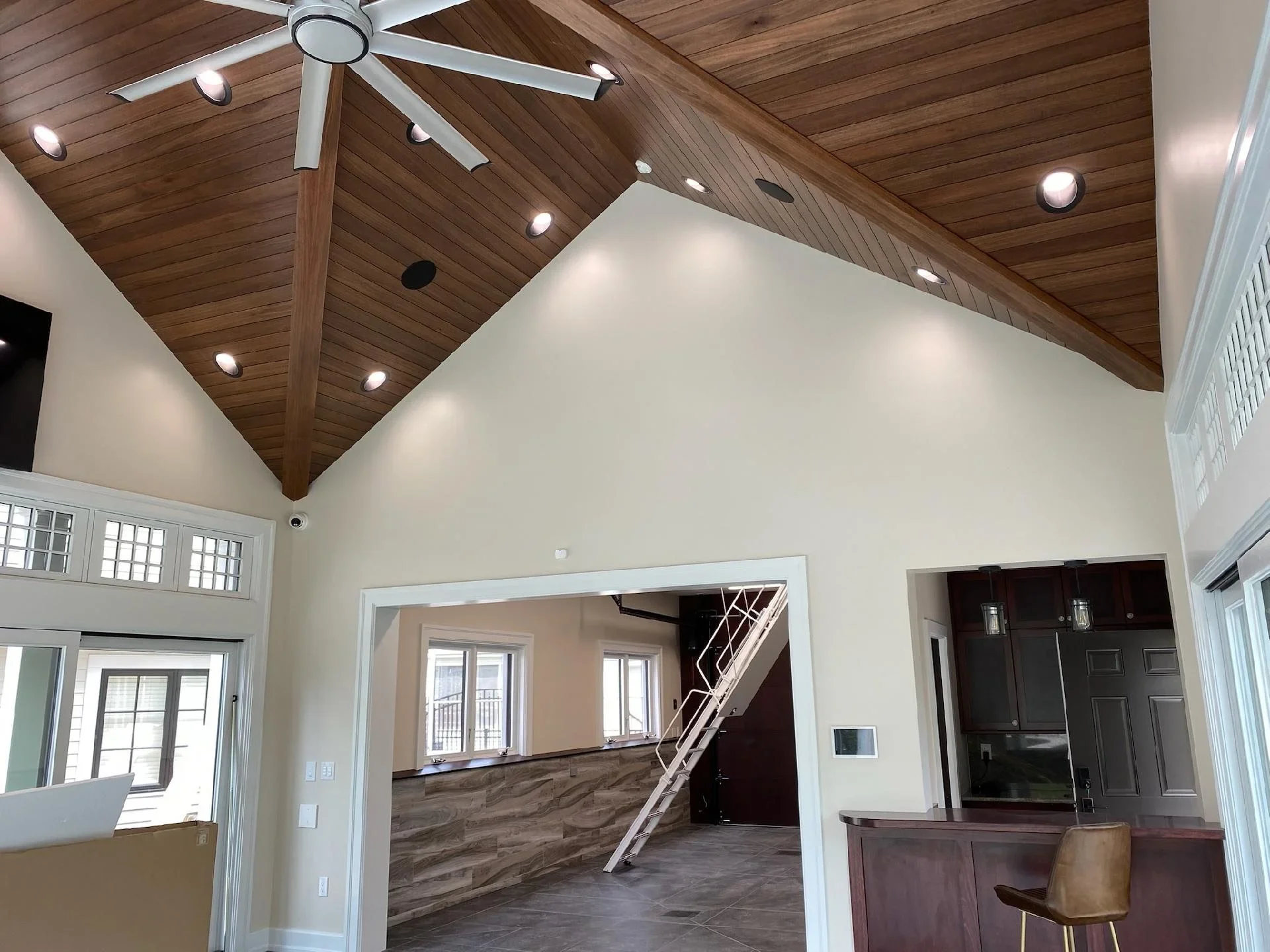 Bright white vaulted ceiling room with wood plank ceiling, recessed lights, and white trim