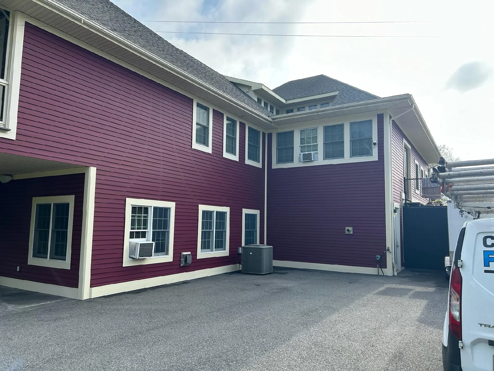 Burgundy and white residential home exterior with painted siding and white-trimmed windows
