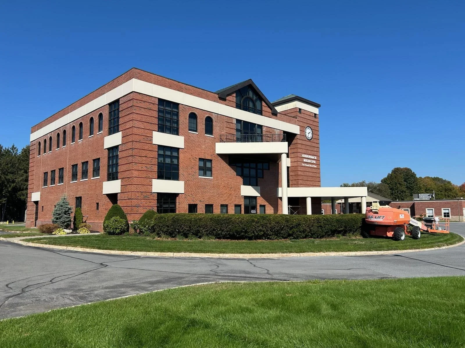 Red brick commercial building with cream trim and white accent bands, freshly painted exterior