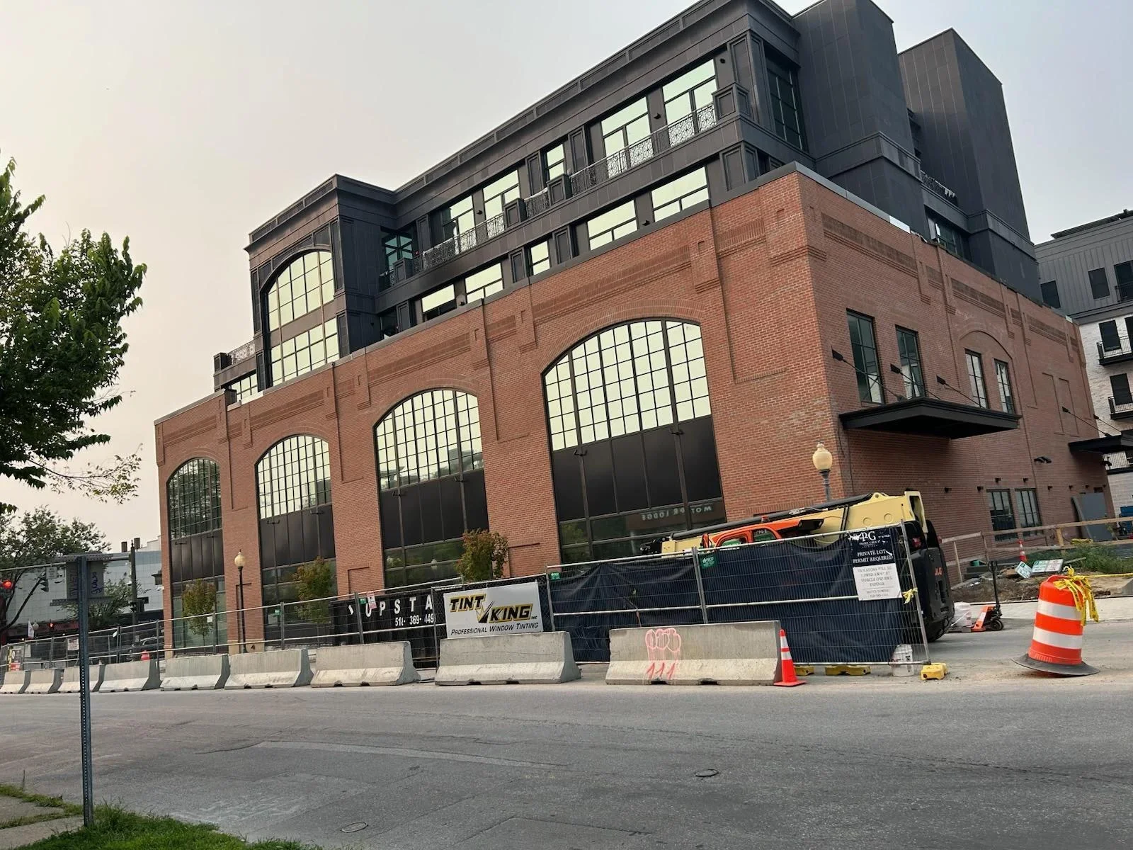 Historic red brick building with large arched windows during professional painting and tinting work