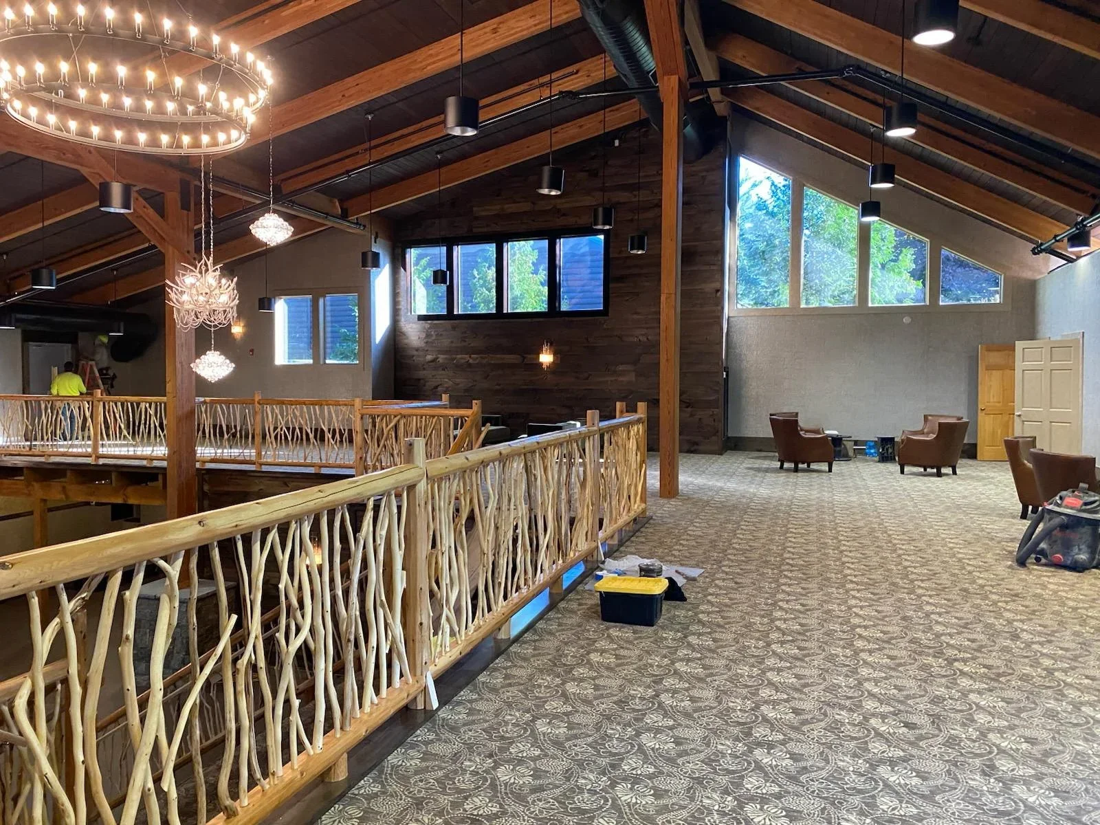 Commercial interior with painted walls, wooden beams, pendant lighting, and custom railings